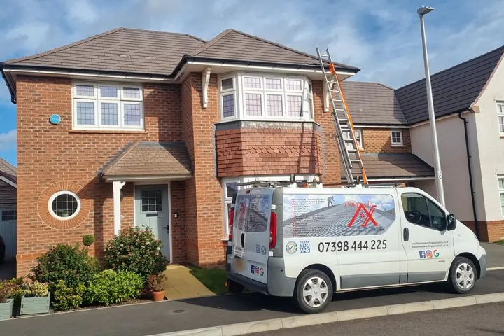 A white van signwritten for Pinnacle Roofing Specialists, parked outside a red-brick detached house with a ladder up to the roof